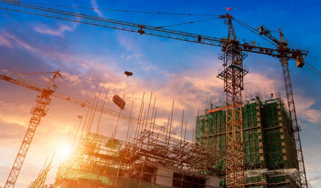 construction of tower blocks in sunset with cranes