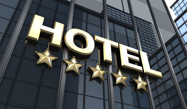 big gold signe hotel and 5 starts on the black glass facade